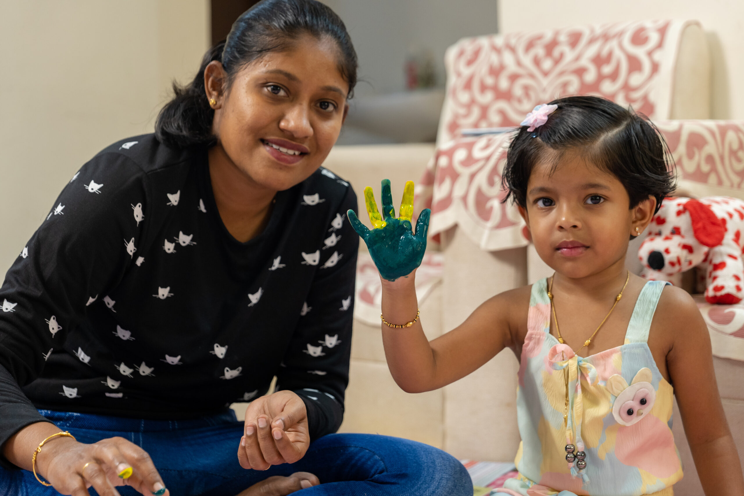 Small girl kid show the hand which were painted with color green and yellow and she smiling